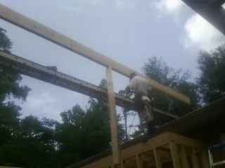 Carpenter setting a ridge beam over a new addition frame — Ice Dam Removal by Roofing Brothers in Edgeley