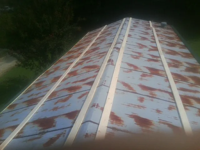 Rusted metal roof panels with new wood purlins before replacement — Storm Damage Roof Repair in Edgeley by Roofing Brothers