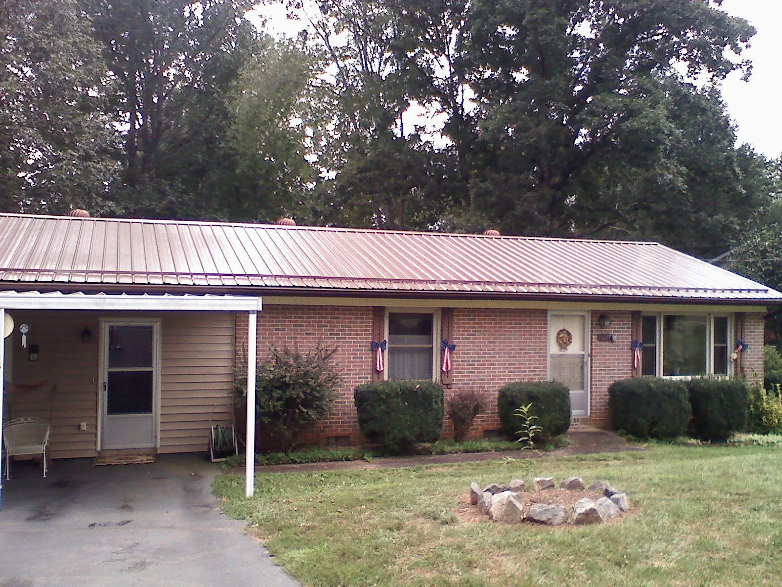 Bronze metal roof and carport on a brick ranch home — Roof Repair work by our crew in Edgeley